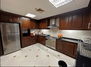 a kitchen with wooden cabinets and stainless steel appliances at Bangkok CBD Pinky Vibe Villa in Bangkok