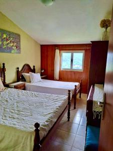 una camera con due letti e una finestra di Mélita Guesthouse a Braga