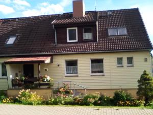 a yellow house with a brown roof at Ferienwohnung in Harzungen