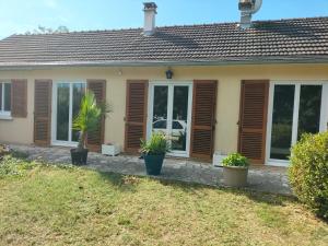 een huis met ramen en planten ervoor bij Au Bois Fleuri in Bracieux