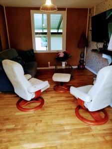 Duas cadeiras brancas e uma mesa numa sala de estar em Au Bois Fleuri em Bracieux