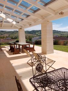 a patio with a table and chairs under a roof at Villa luce e relax in Saturnia