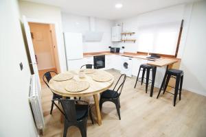 a kitchen with a table and chairs in a room at Apartamentos 2K - Apartamento en muelle Olabeaga in Bilbao +7 photos