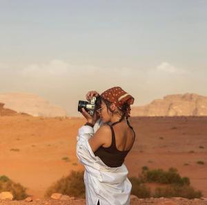 a woman taking a picture of the desert at Bedouin bunch camp in Wadi Rum