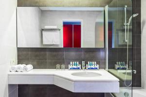 a bathroom with a sink and a glass shower at Skiathos Palace Hotel in Koukounaries