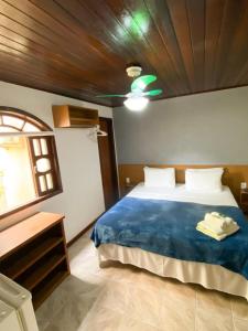 a bedroom with a blue bed with a wooden ceiling at Pousada Bugio in Abraão