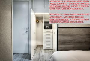 sypialnia z łóżkiem i ścianą z znakiem w obiekcie Guesthouse Foresteria Margherita Milano w Mediolanie