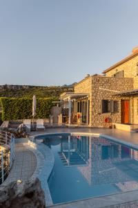 a swimming pool in front of a house at Trochalo Villas 2 in Stoupa