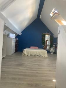 ein Schlafzimmer mit einem Bett und einer blauen Wand in der Unterkunft Chez Christine et Claude in Neufmontiers-lès-Meaux