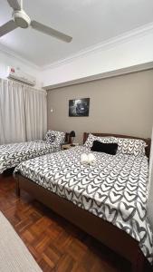 een slaapkamer met 2 bedden en een plafondventilator bij The Hill Regency in Bentong