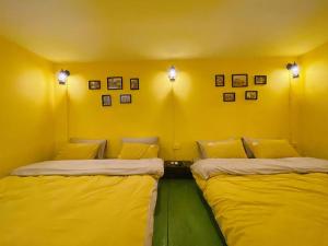 Duas camas num quarto com paredes amarelas em Budget 80s Style Apt @4 guests @WalkingStreet em Hanói