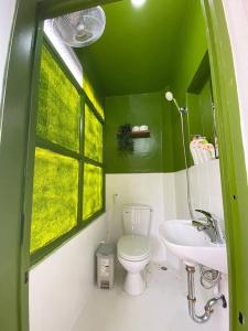 uma casa de banho verde com um WC e um lavatório em Budget 80s Style Apt @4 guests @WalkingStreet em Hanói