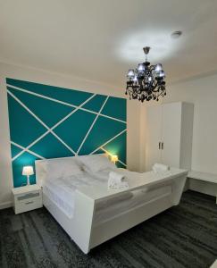 Un dormitorio con una gran cama blanca y una lámpara de araña. en BTP House en Hunedoara