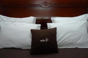 un grupo de almohadas blancas en una cama en The Kei Suites en Calcuta