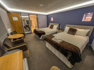 ein Hotelzimmer mit 2 Betten und einem Tisch in der Unterkunft Fountain House in Boston