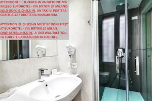 W łazience znajduje się umywalka, lustro i prysznic. w obiekcie Guesthouse Foresteria Margherita Milano w Mediolanie +15 zdjęć