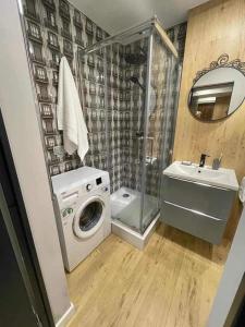 a bathroom with a washing machine and a sink at Łódź You Like in Łódź