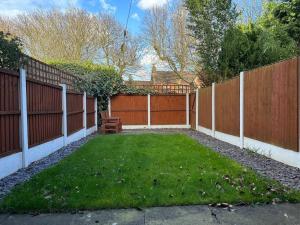 a backyard with a fence and a green yard at Cosy home in Warrington in Great Sankey