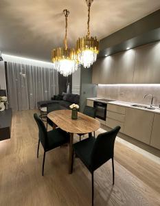 een keuken en eetkamer met een tafel en stoelen bij DOM Boutique Apartments - Verde in Belgrado