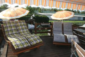 zwei Stühle und zwei Sonnenschirme auf einer Terrasse in der Unterkunft Ferienwohnung Annett in Böhlen