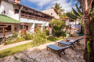 un patio con tavolo e sedie di fronte a una casa di Feiticeira Praia Hotel a Ilhabela