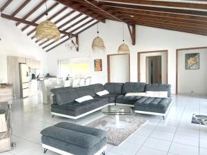a living room with a couch and a table at Villa spacieuse avec piscine au Gosier - Vue sur mer in Le Gosier