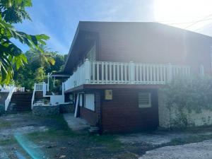 a house with a balcony on the side of it at Villa spacieuse avec piscine au Gosier - Vue sur mer in Le Gosier