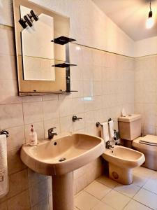 bagno con lavandino, servizi igienici e specchio di Mélita Guesthouse a Braga