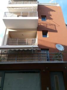 een appartementencomplex met een balkon en een satelliet-tv bij Makis rooms C in Mesolongion