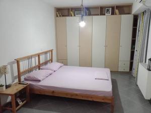 1 dormitorio con 1 cama, mesa y armarios en Makis rooms C, en Mesolongi