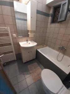 een badkamer met een toilet, een bad en een wastafel bij Makis rooms C in Mesolongion