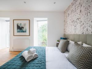una camera da letto con un letto e asciugamani di Pass the Keys London Modern EcoTownhouse Dulwich a Londra