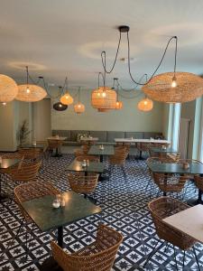 a restaurant with tables and chairs and chandeliers at Hotel Das Regensburg in Regensburg