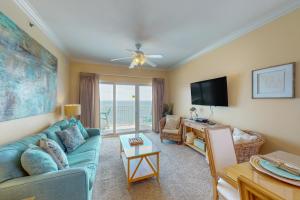 a living room with a blue couch and a television at Seawind #1109 in Gulf Shores