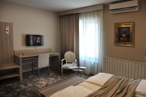 una camera d'albergo con un letto e una scrivania con un computer di Hotel VIP a Sarajevo