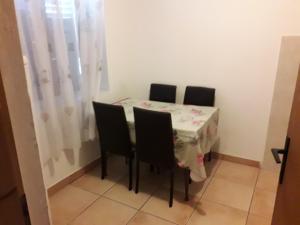 een eettafel met 4 stoelen en een wit tafelkleed bij Apartman Lovcen in Budva