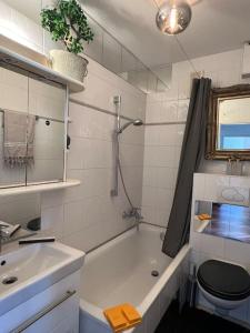 een badkamer met een bad, een toilet en een wastafel bij Bestlage Schwabing Ganze Wohnung in München