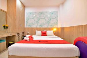 a bedroom with a large bed with a red blanket at HANZ Love Hotel Tran Binh Trong in Ho Chi Minh City
