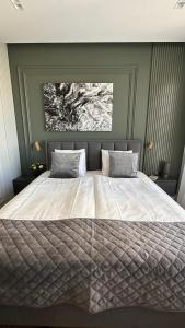 een slaapkamer met een groot bed met een witte sprei bij DOM Boutique Apartments - Verde in Belgrado