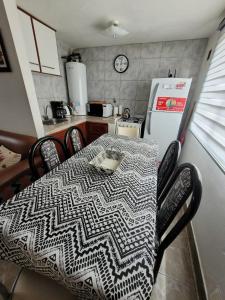 uma cozinha com uma mesa e um frigorífico branco em RyG Apartments em San Carlos de Bariloche