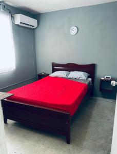 - une chambre avec un lit rouge et une horloge murale dans l'établissement Renta por mes Departamentos en Altamira Tamaulipas, 