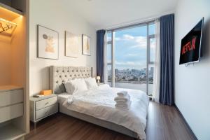a bedroom with a bed and a large window at Fully-Equipped Luxury Condo in Central Ho Chi Minh with Downtown and River View in Ho Chi Minh City