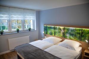 1 dormitorio con 1 cama con una pintura en la pared en Landgasthof Obersteberg en Sprockhövel