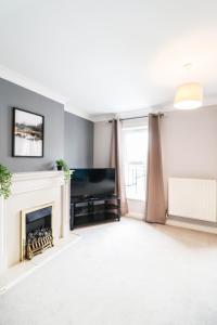 a living room with a fireplace and a television at 4 Bedroom House with FREE WIFI AND DRIVEWAY! in Hillingdon