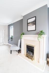 a living room with a fireplace and a chair at 4 Bedroom House with FREE WIFI AND DRIVEWAY! in Hillingdon