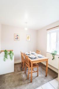 una sala da pranzo con tavolo e sedie in legno di 4 Bedroom House with FREE WIFI AND DRIVEWAY! a Hillingdon