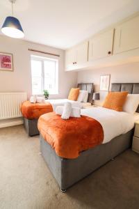 a bedroom with two beds and a large window at Family-Friendly 4 Bedroom House with Private Driveway in Hillingdon