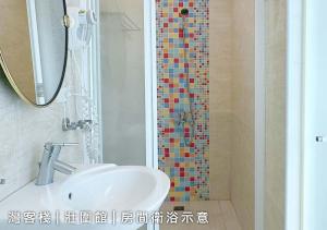 y baño con lavabo y ducha de mosaico. en 灣客棧壯圍56館 en Yilan City