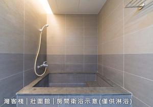 een badkamer met een bad en een douche bij 灣客棧壯圍56館 in Yilan