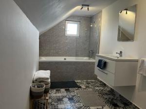 ein Badezimmer mit einem Waschbecken und einer Badewanne in der Unterkunft North Transylvania room 2 